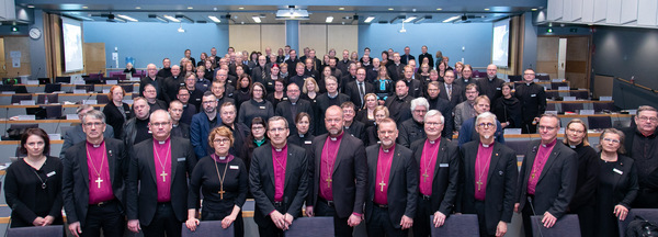 miehiä ja naisia seisomassa ryhmäkuvassa osalla papin ja piispan asut päällä