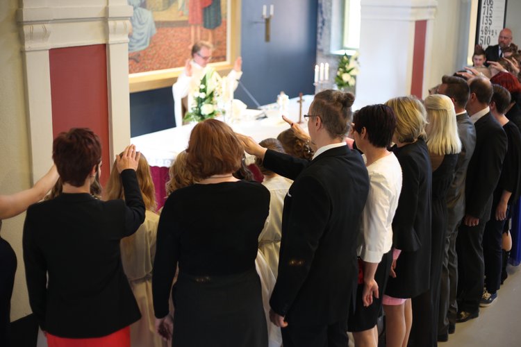 Kummit siunaamassa konfirmoitavia.