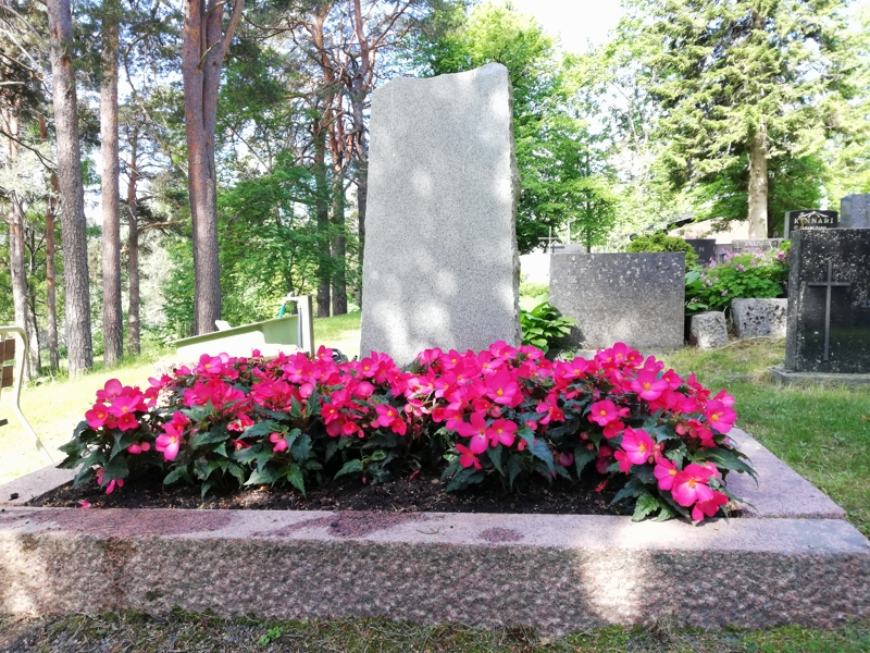 pinkkejä kukkia hautakiven edessä