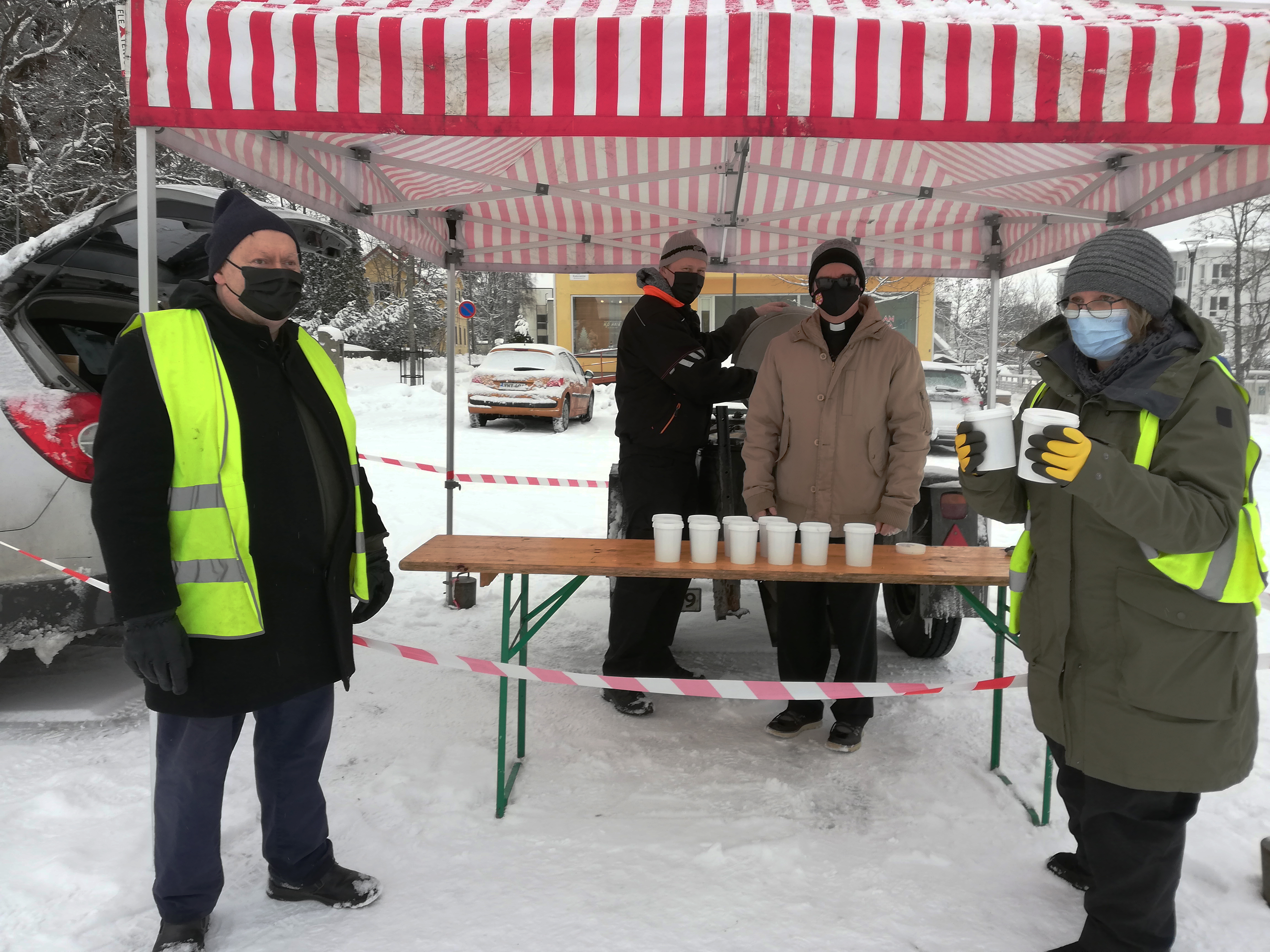 ihmisiä maskit kasvoilla soppatykin luona torilla